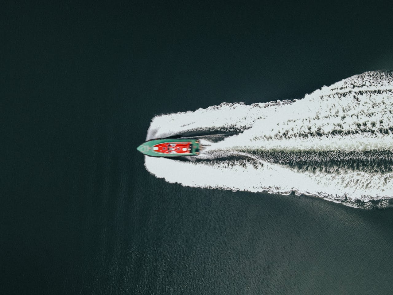 Top view of a speedboat cutting through the water near Greenock, Scotland, creating a dramatic trail.